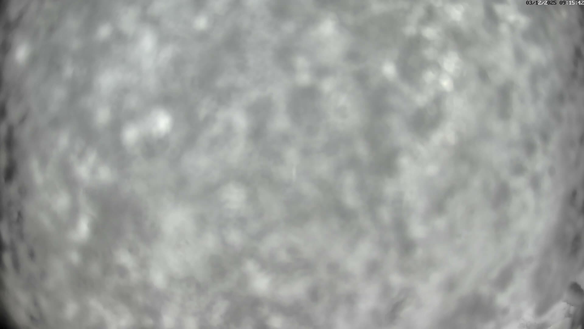 A heavily overcast sky is depicted as a blurry, mottled expanse of light and dark grey clouds.