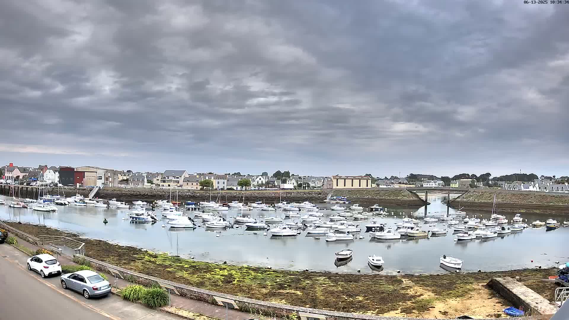 A harbor filled with numerous small boats under a cloudy sky.
