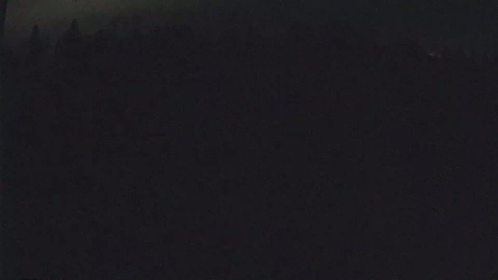A dark, possibly nighttime, image shows an indistinct, shadowy mass at the top, suggesting a distant landscape or skyline.