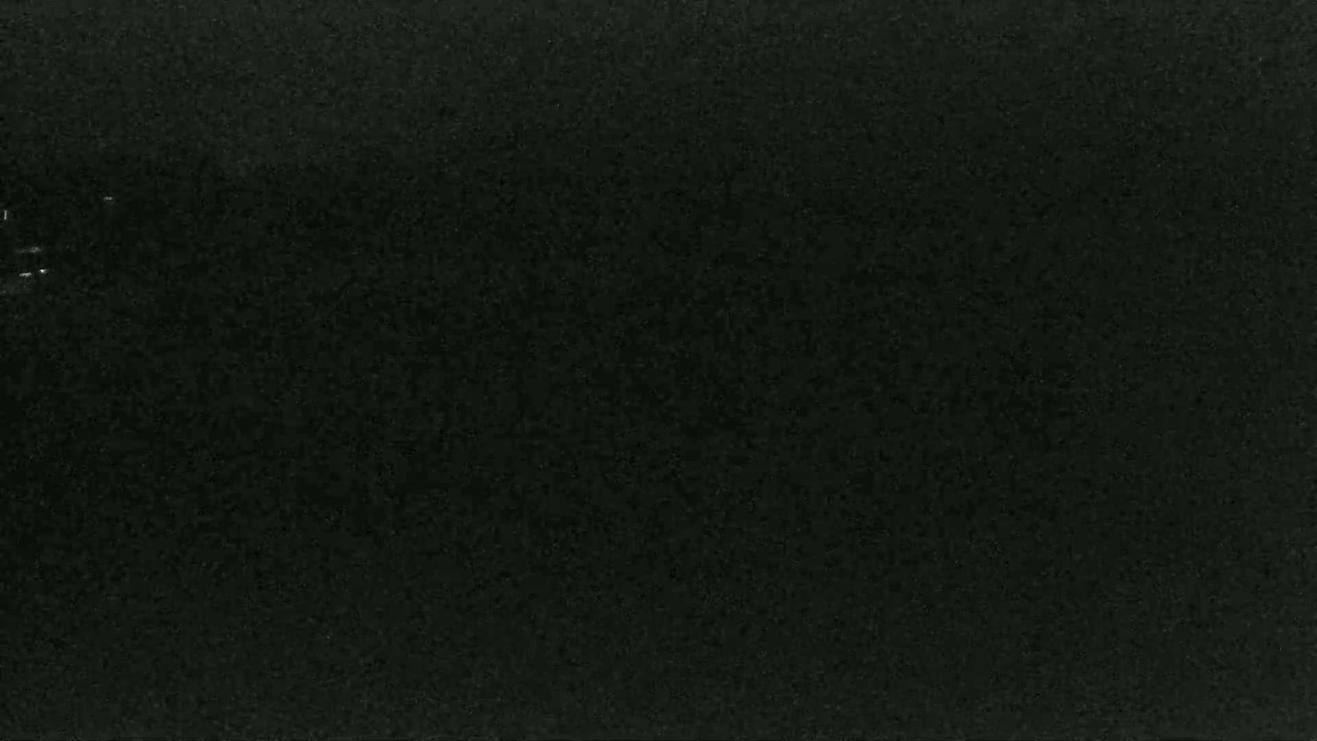 A dark, mostly black image shows a few faint, lighter specks.