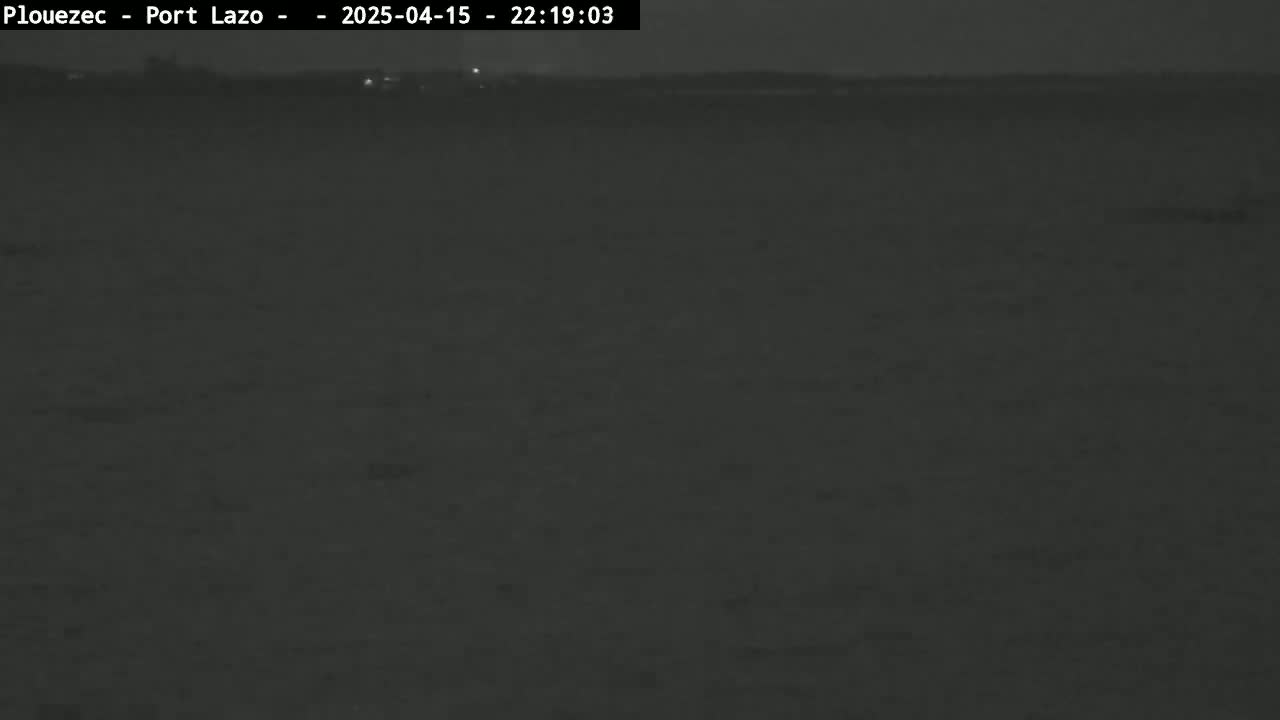 A dark, nighttime view of a flat, seemingly empty landscape under a clear sky.
