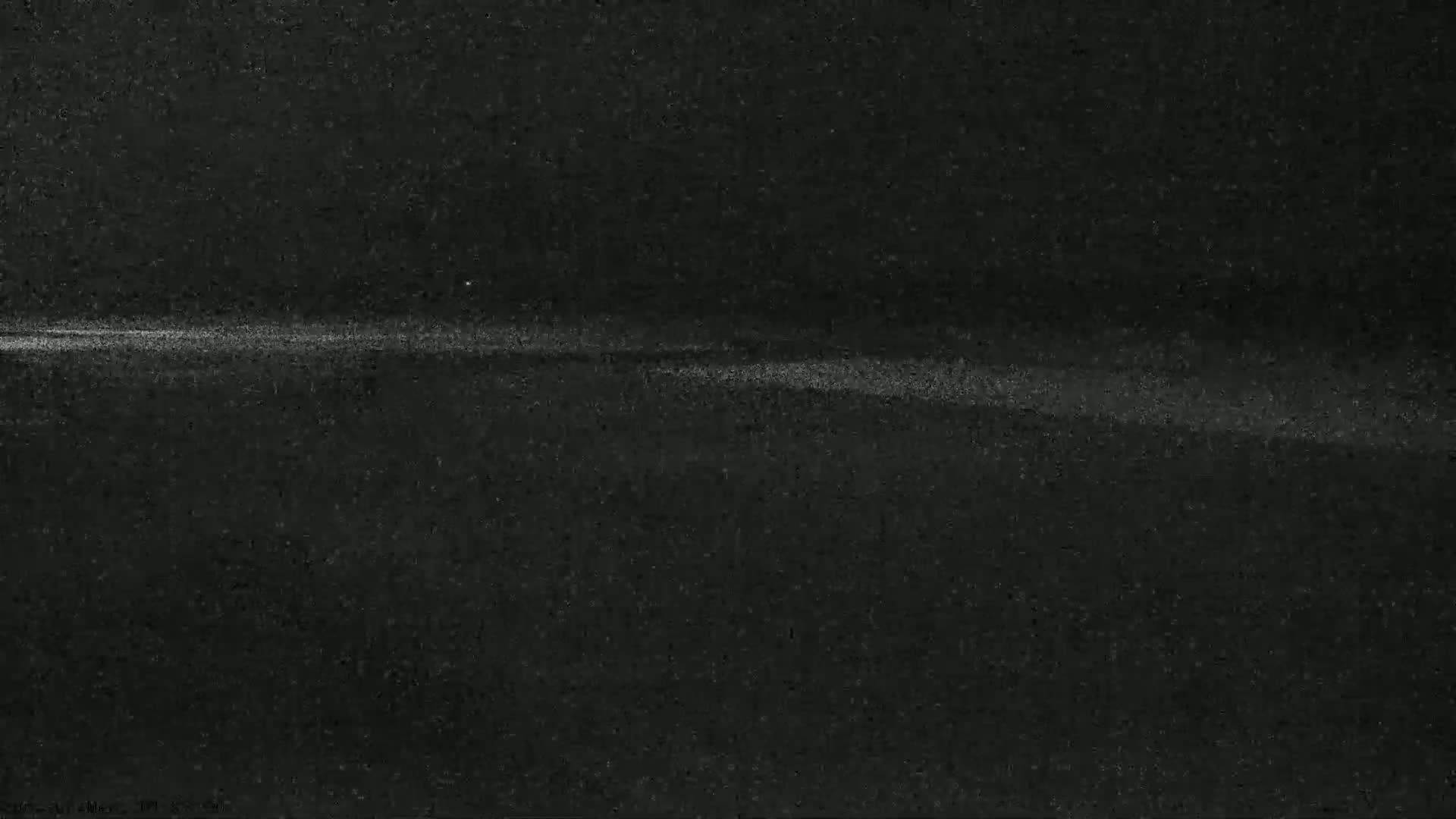A grainy, dark image shows a faint, horizontal line of light against a mostly black background.
